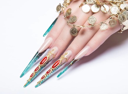 Long beautiful manicure on the fingers of turquoise and red. Nails design. Picture taken in the studio on a white background. Isolate object