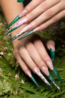 Long beautiful manicure with flowers on female fingers. Nails design. Close-up