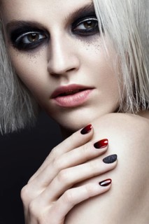 Beautiful blond girl with dark smokey makeup and art manicure design nails. beauty face. Photos shot in studio