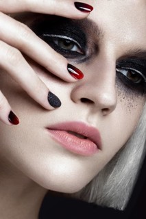 Beautiful blond girl with dark smokey makeup and art manicure design nails. beauty face. Photos shot in studio