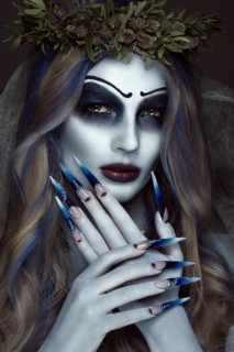 Portrait of a horrible scary Corpse Bride in wreath with dead flowers