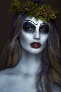 Portrait of a horrible scary Corpse Bride in wreath with dead flowers