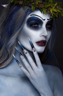 Portrait of a horrible scary Corpse Bride in wreath with dead flowers