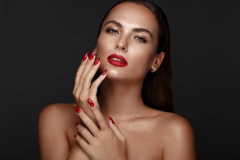 Beautiful girl with a classic make up and multi-colored nails. Manicure design. Beauty face. Photo taken in the studio