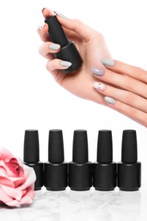 Black bottles of nail polish on a background of flowers. Manicure design