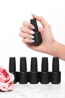Black bottles of nail polish on a background of flowers. Manicure design