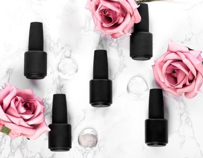 Black bottles of nail polish on a background of flowers. Manicure design