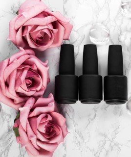 Black bottles of nail polish on a background of flowers. Manicure design