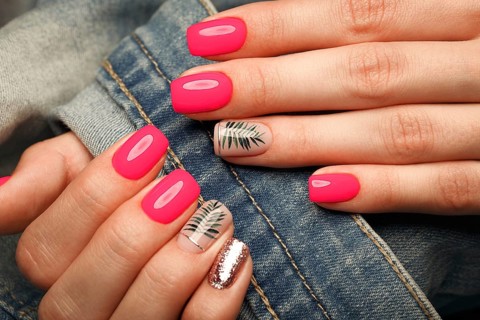 Bright neon manicure on female hands on the background of jeans. Nail design. Beauty hands