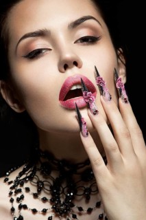Beautiful girl with long nails and sensual lips. Portrait shot in the studio on a black background.Beauty face