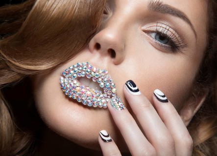 Beautiful girl with bright nails and lips of crystals