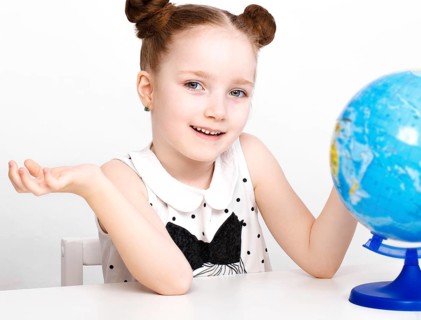 Little girl at the table of a first-grader. Photo taken in the studio