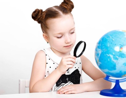 Little girl at the table of a first-grader. Photo taken in the studio