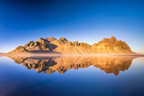 Mountain massif reflected in water
