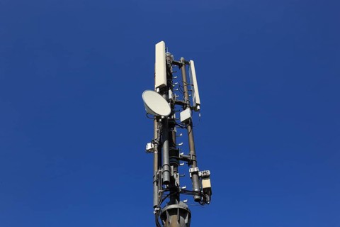 Transmission mast with directional radio antenna and antennas for mobile phone reception