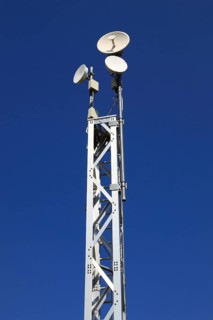 Transmission mast with directional radio antenna and antennas for mobile phone reception