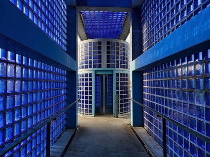 Access to the S-Bahn platform with lift made of blue glass blocks and exposed concrete