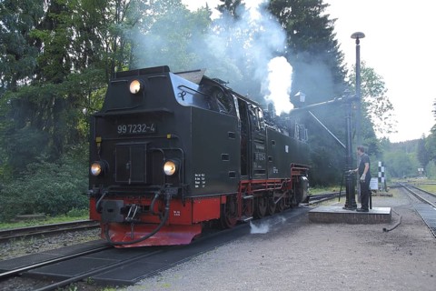 Steam locomotive refuelling water at the water crane