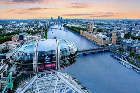 Gondola of the London Eye Ferris Wheel over the Thames with the Houses of Parliament in the evening mood