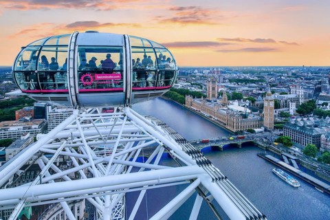 Gondola of the London Eye Ferris Wheel over the Thames with the Houses of Parliament in the evening mood