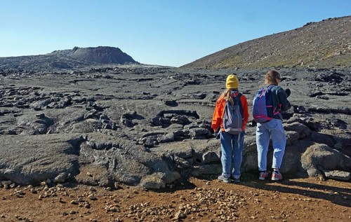 Women hikers standing in front of solidified lava