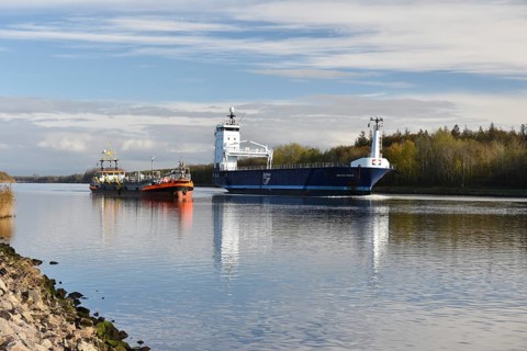 Cargo ship overtakes suction dredger in Kiel Canal