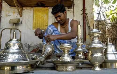 An artisan working carving on brass lamp at NachiyarKoil Nachiyar Koil near Thanjavur Tanjore
