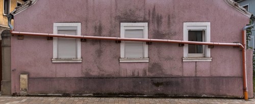 Drain pipe runs across the windows of a single-family house