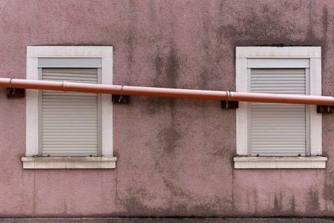 Drain pipe runs across the windows of a single-family house