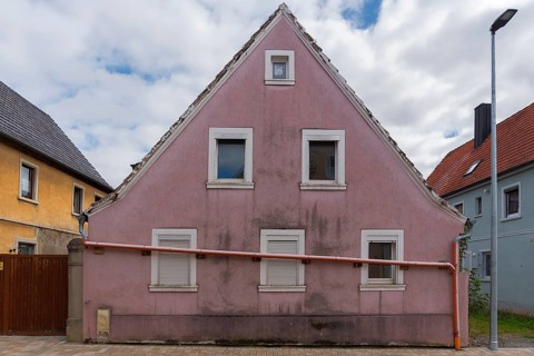 Single-family house with a drain pipe in front of the facade