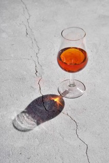 Glass of brandy on concrete background