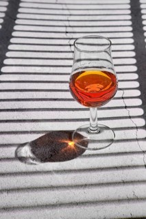 Glass of brandy on concrete background