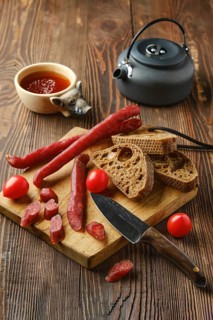 Dry thin pork sausage on cutting board