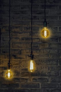 Vintage edison light bulbs on wire with brick wall on background