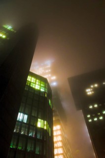Illuminated skyscrapers in the fog at night