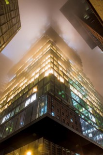 Illuminated skyscrapers in the fog at night