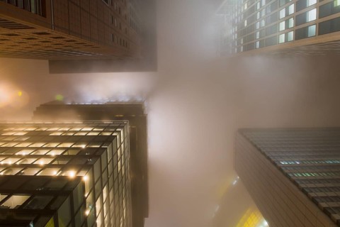 Illuminated skyscrapers in the fog at night