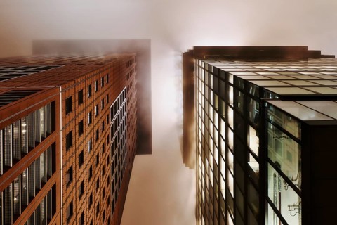 Illuminated skyscrapers in the fog at night