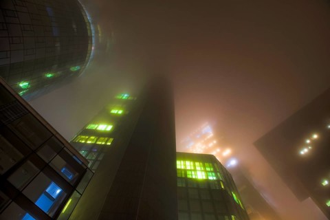 Illuminated skyscrapers in the fog at night