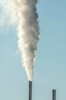 Column with smoke coming out of an industrial chimney. France