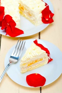 Whipped cream mango cake with red rose petals