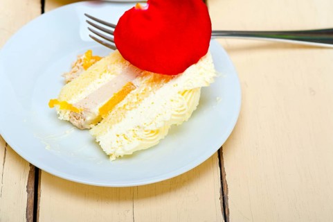 Whipped cream mango cake with red rose petals