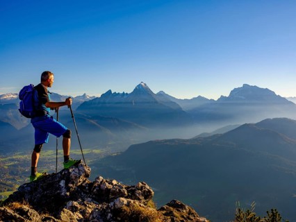 Mountaineer at the summit Rauher Kopf looking at the Berchtesgaden Alps