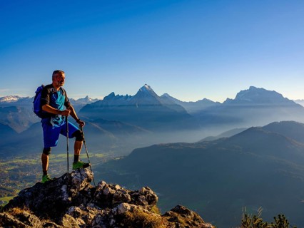 Mountaineer at the summit Rauher Kopf looking at the Berchtesgaden Alps