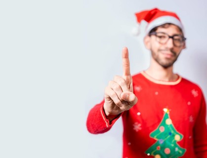 Man in christmas hat counting number one with finger. Man in christmas costume counting number one with finger. Concept of man in christmas costume counting number one isolated