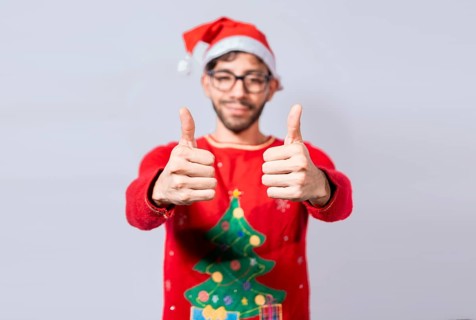 Young man in christmas hat giving thumbs up with both hands. People in santa hat ok gesture with fingers isolated. Christmas man concept with thumbs up in ok gesture