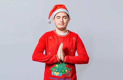 Guy with hands together praying in christmas isolated