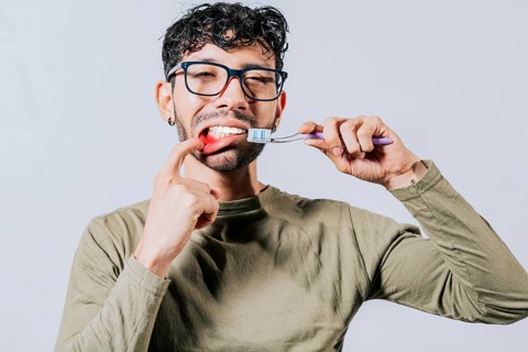 Man holding toothbrush with gum pain