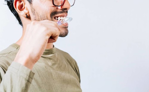 Face of person brushing teeth isolated with copy space. Man brushing his teeth isolated