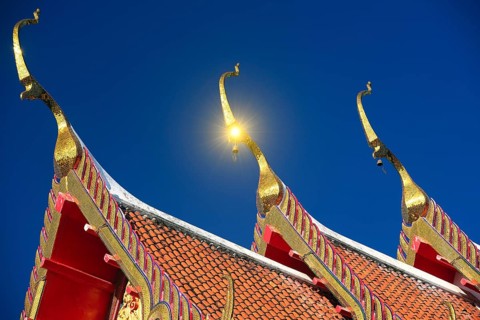 Roof ornaments and pagodas with reflections of the sun